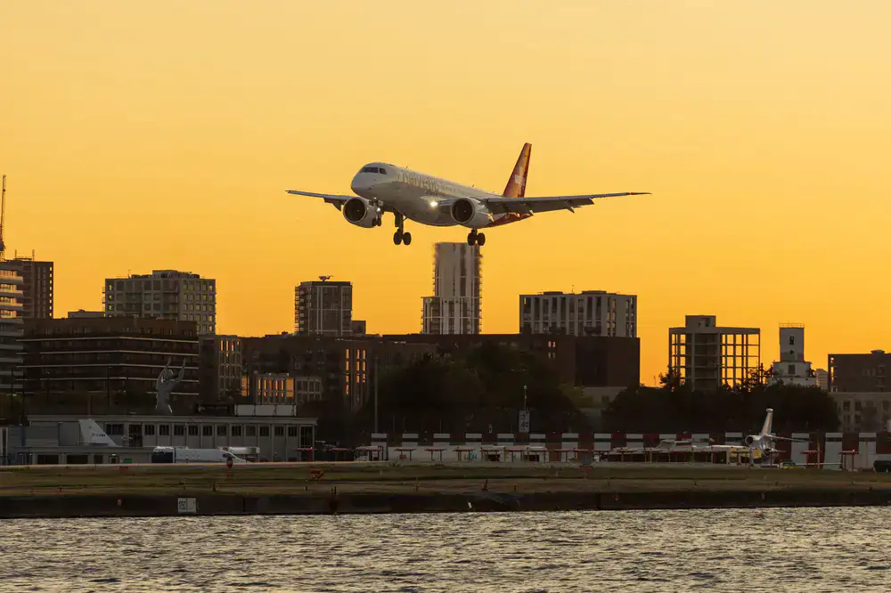 Commercial passenger jet flying over a city at sunset in mobile simulator